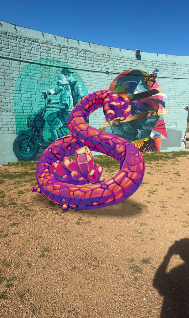 AR snake sculpture in front of a mural